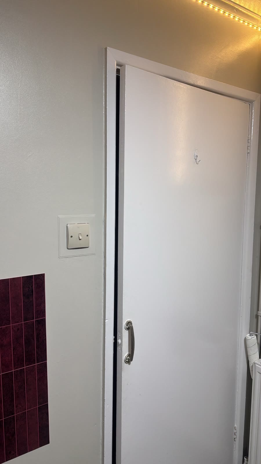 Newly painted white door and frame beside a light switch